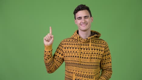 young handsome man thinking while pointing finger up