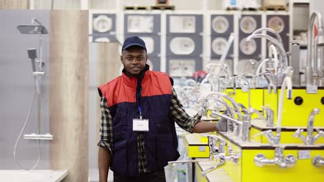 Salesman-standing-between-rows-in-household-hypermarket,-looking-to-the-camera