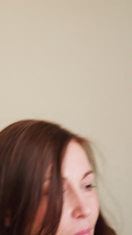 close-up of businesswoman in gray blazer walking through office hallway with calm expression and closed eyes, suggesting moment of reflection, confidence, or composure in quiet professional setting