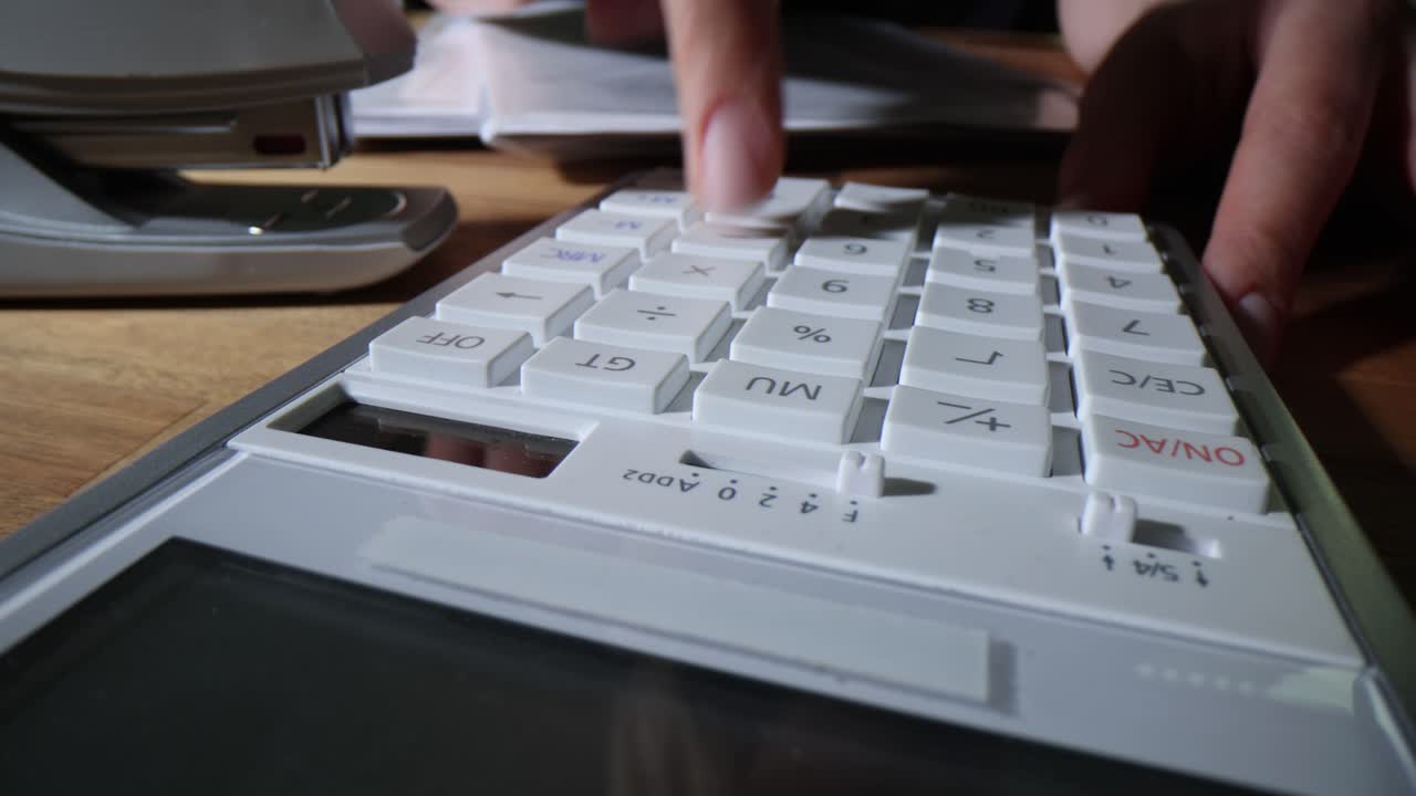 Close-up of Hands Operating a Calculator for Business or Financial Calculations