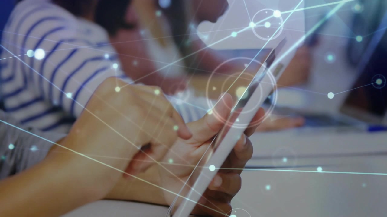 Hands tapping and swiping tablet in lab initiating network overlay wrapping around tablet for class