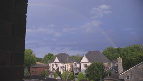 a rainbow appears over a neighbourhood after the storm