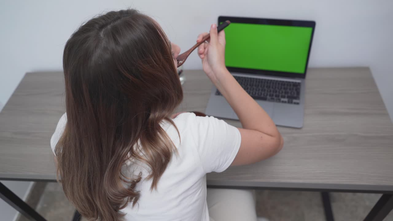 Woman eating lunch at her laptop