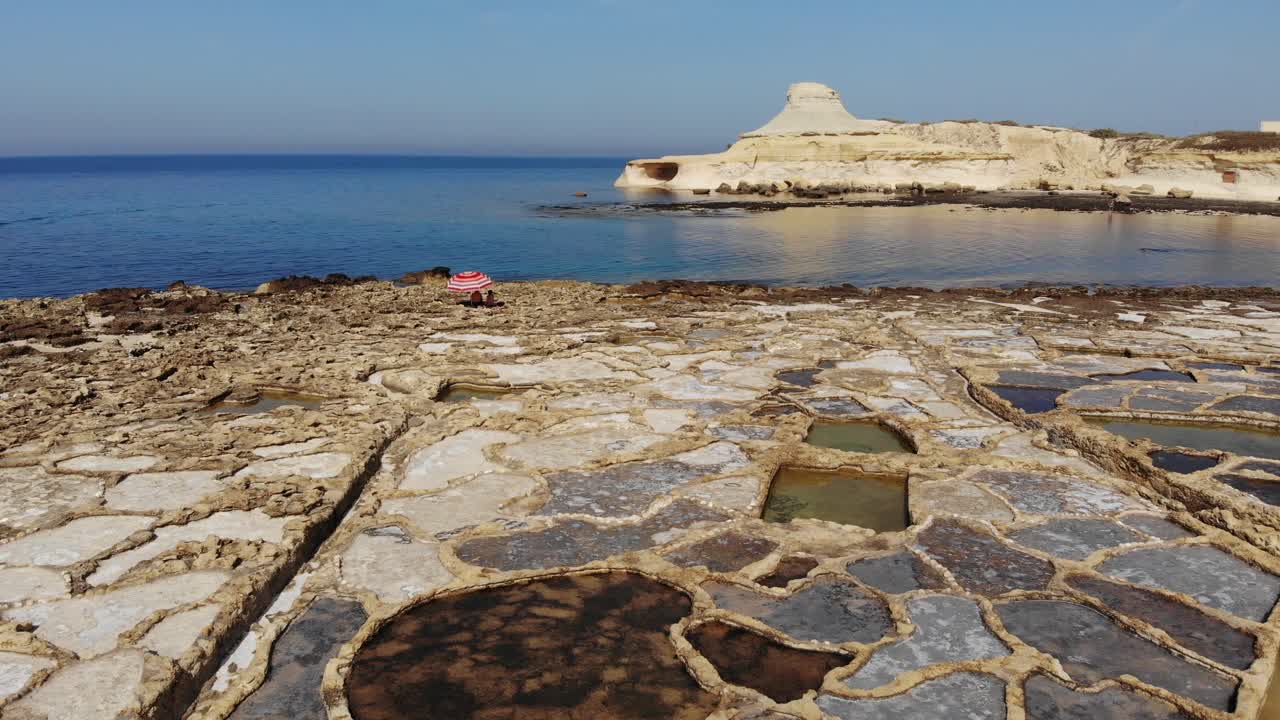 몰타의 고조 섬에 있는 암석 절단 염전, qbajjar 만 및 marsalforn을 가로지르는 공중 드론 샷