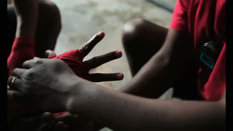 african american male trainer assisting boxer in wearing hand wrap in gym 4k