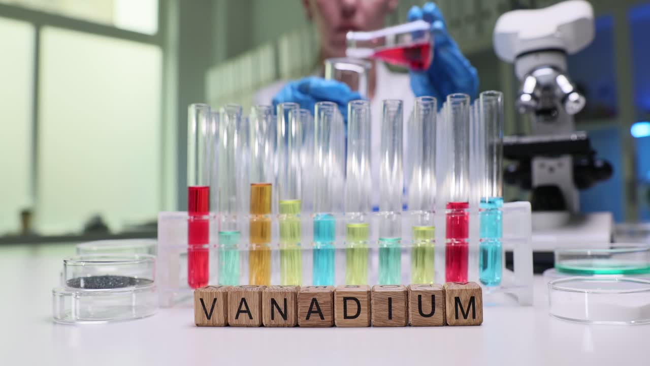 Wooden blocks spell vanadium as lab chemist tests solutions