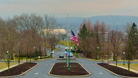 us flag flying at half-mast on pole with overcast skies and mountain in background