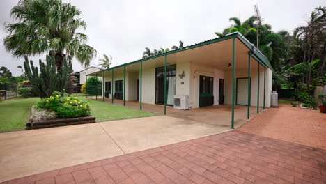 Pequeña-Casa-Australiana-Al-Estilo-De-Texas-Con-Planta-De-Cactus-Mientras-El-Pájaro-Urraca-Se-Lanza-Para-Aterrizar-En-El-Camino-De-Entrada,-Cámara-Lenta