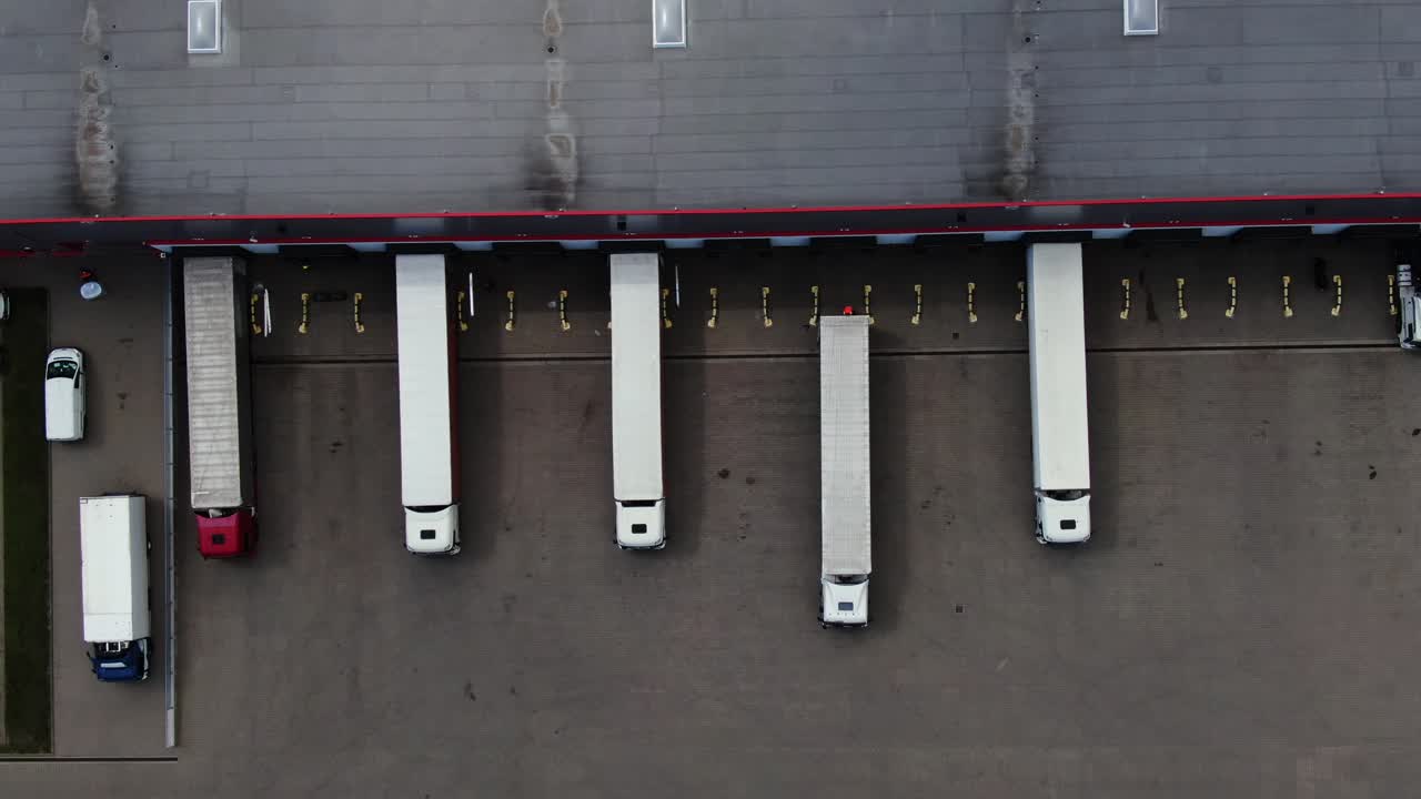 semirremolque con remolque de carga viaja a lo largo de un estacionamiento de un almacén en el parque logístico