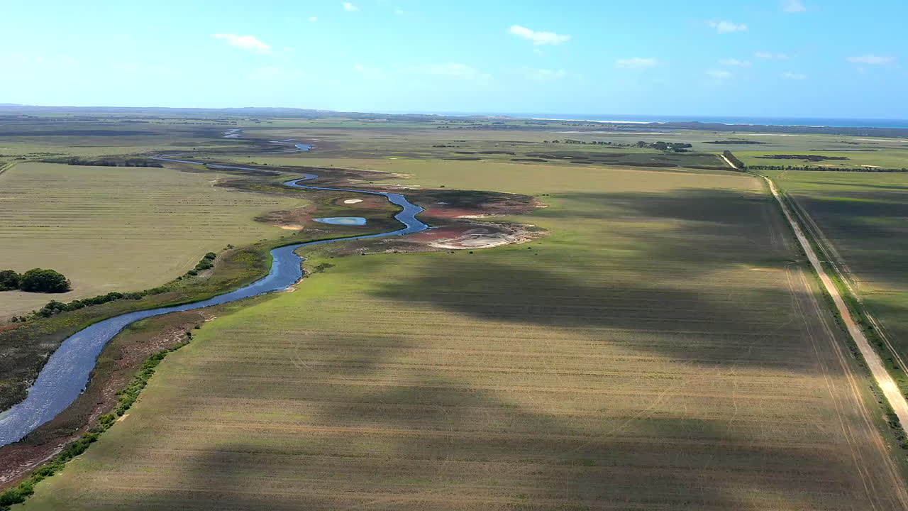 vista aérea de un río sinuoso a través de tierras de cultivo y paisaje costero