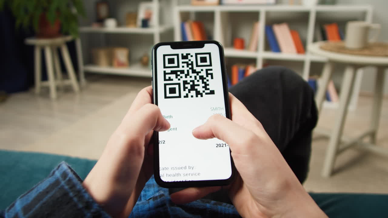 Person Holding Smartphone Displaying Digital Vaccination Certificate with QR Code
