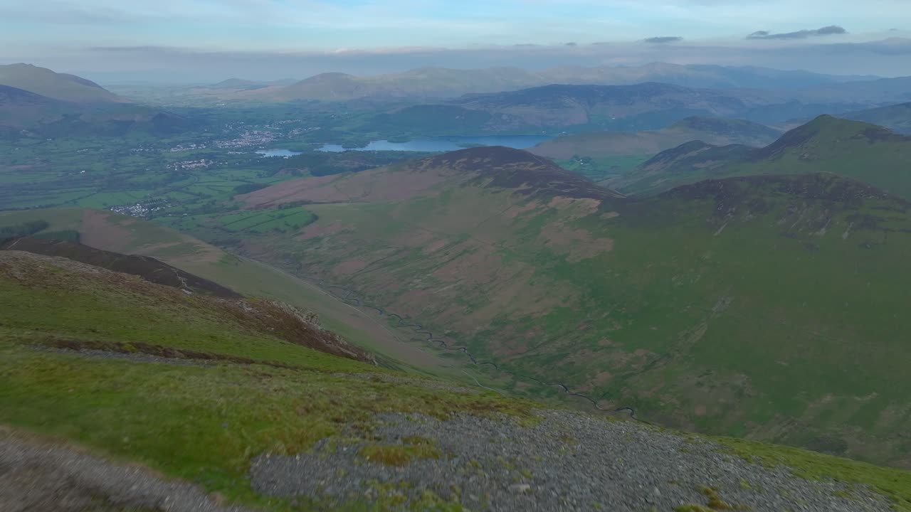 해가 지기 전에 깊은 계곡, 저지대, 호수를 드러내는 플라이오버와 함께 정상에 있는 산책자
