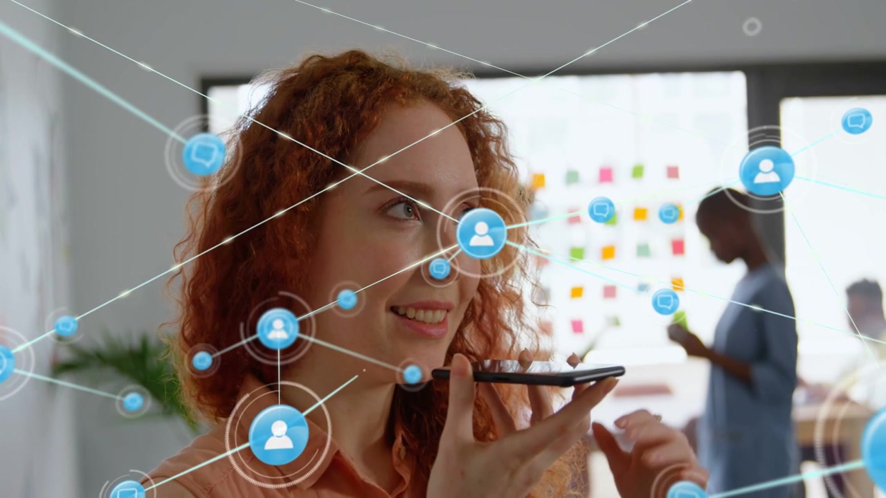 Woman lifting smartphone, speaking and updating team in tech office, while network links expanding