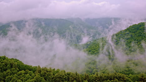 aerial cinematic view of the smoky mountains blanketed in fog and mist