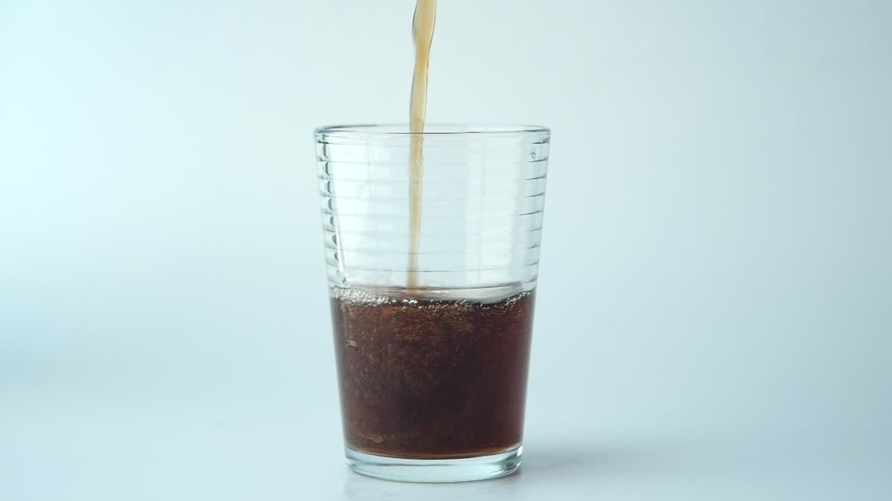 un vaso de cola con hielo y burbujas