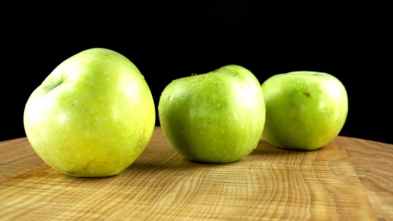 Æbler på sort baggrund. Skærebræt i bevægelse.