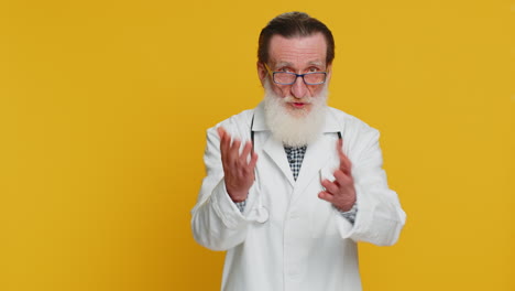 Senior doctor man shakes finger and saying no be careful avoid danger mistake disapproval sign