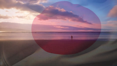 digital composition of waving japan flag against man walking on the beach