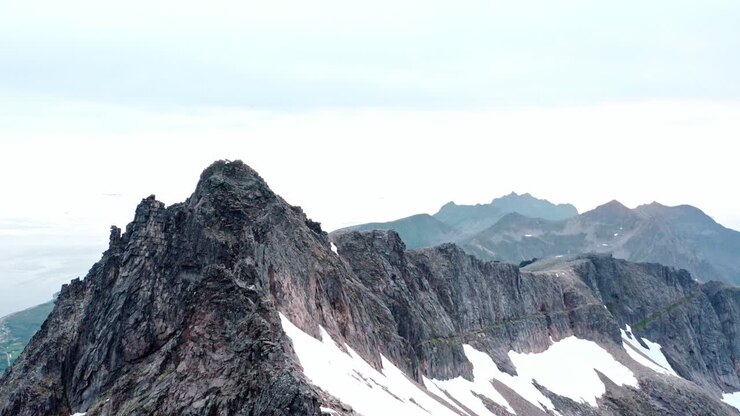 Cima rocciosa del Monte Kvaenan con neve sulle ripide scogliere in Norvegia.