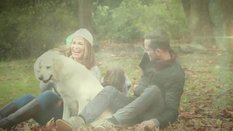 spot of light against caucasian family playing with their dog in the garden