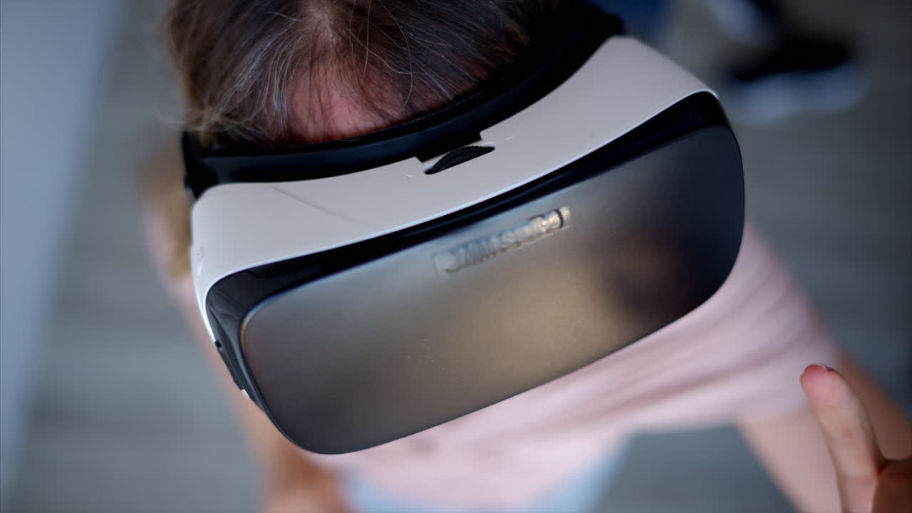 Woman with long hair wearing black VR virtual reality headeset and playing