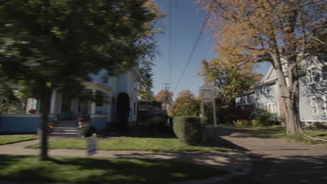 Drive-along-a-typical-street-of-an-American-town-on-a-clear-autumn-day.-Side-view