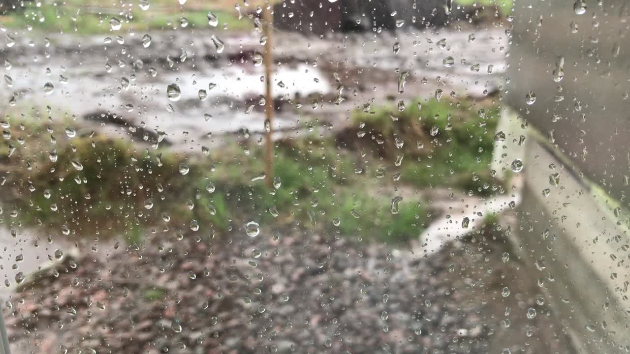 Close-up of raindrops on the window. A drop of water rolls over the glass