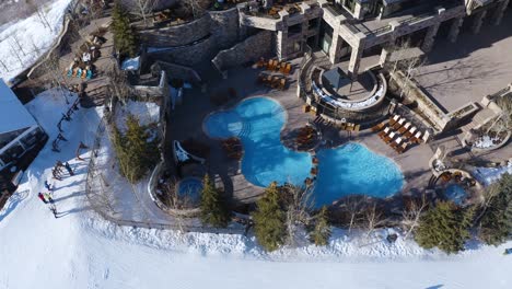 Skifahrer-In-Der-Nähe-Eines-Luxusresorts-Mit-Pool-Und-Sitzecke-In-Deer-Valley-Park-City,-Utah