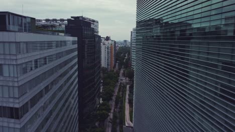 track drone shot between cristal buildings over old railroad tracks in polanco, mexico city