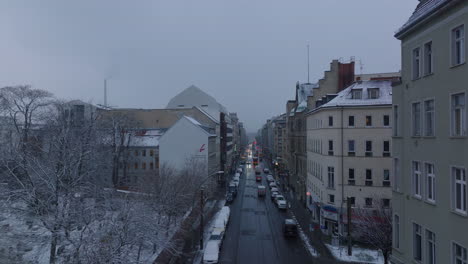 Seguimiento-Hacia-Adelante-De-Los-Automóviles-Que-Conducen-En-Las-Calles-De-La-Ciudad-De-Invierno-Al-Atardecer.-Volar-A-Lo-Largo-De-Los-Edificios-De-Apartamentos.-Berlín,-Alemania