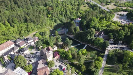 Vista-Aérea-Rodeando-Los-Tejados-De-La-Pequeña-Ciudad-Bosnia-De-Jajce,-Herzegovina-Hermoso-Paisaje-Bosque-árboles-Forestales