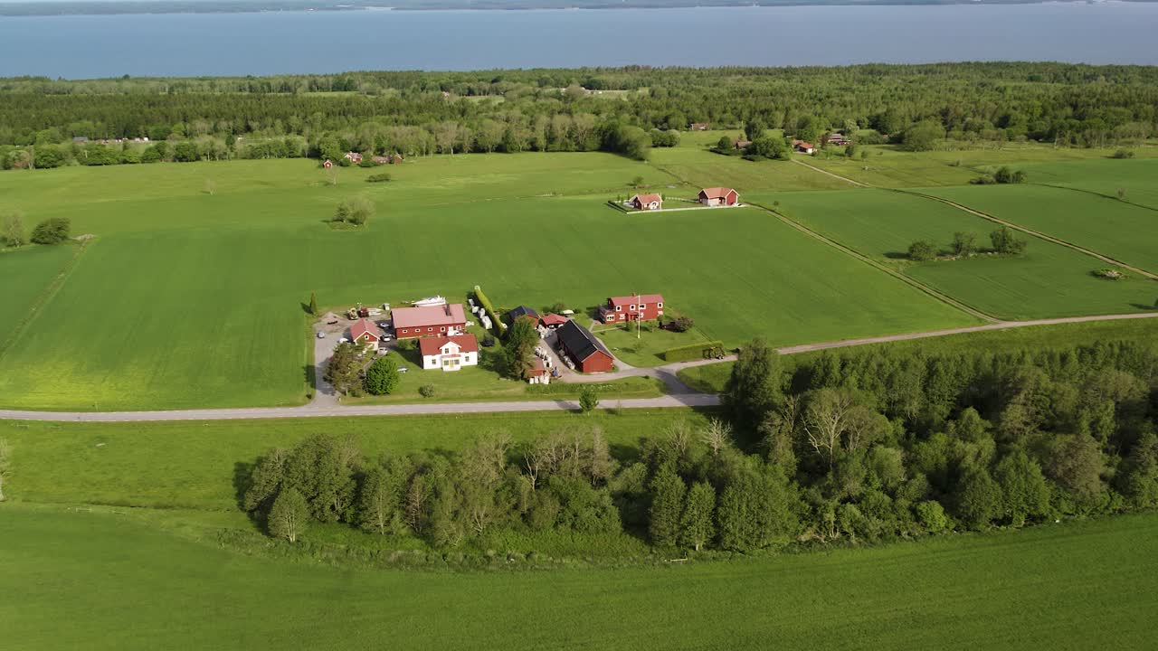 Ilmakuva maalaistaloista, joita ympäröivät vehreät pellot ja metsä kesällä Kinnekullessa, Hallekisissa, Ruotsissa.