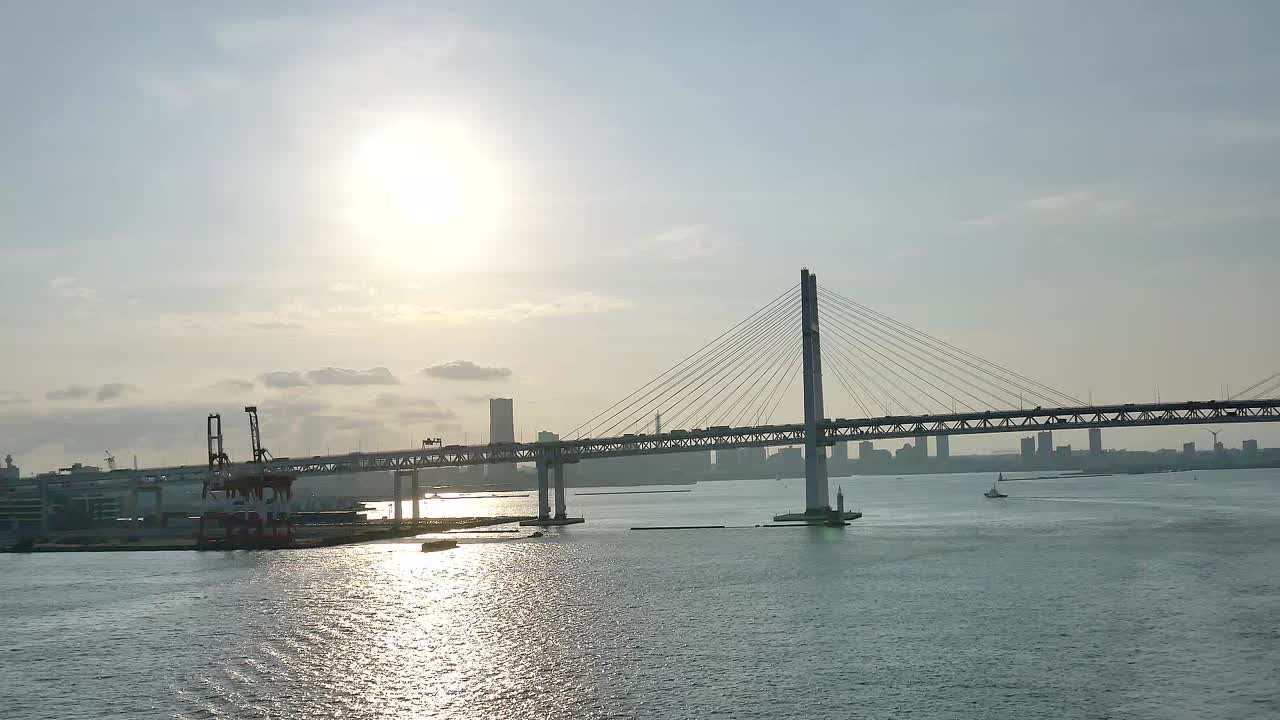 A wide shot of the Yokohama Bay Bridge taken from the cruise ship top deck, capturing ocean views and towering bridge spans