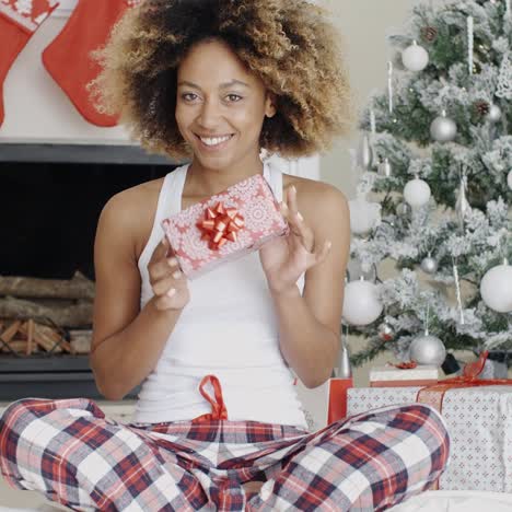 Happy-young-woman-holding-her-Christmas-gift