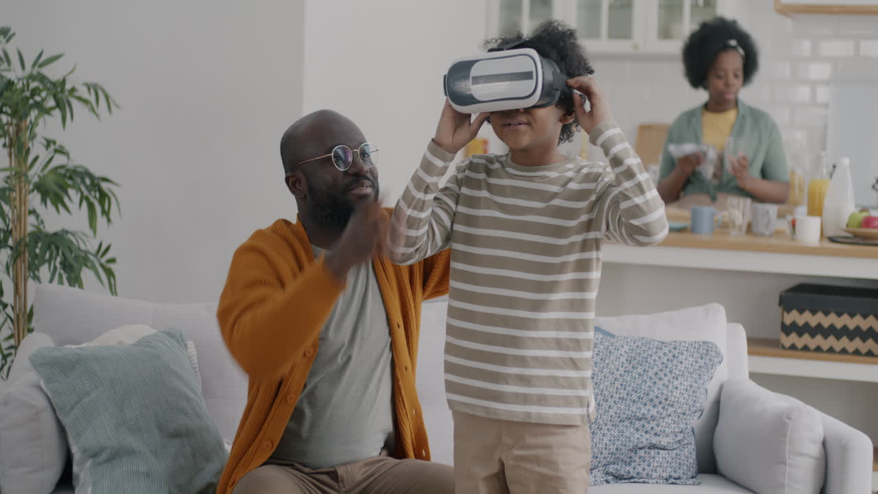 Father and son playing with VR headset at home