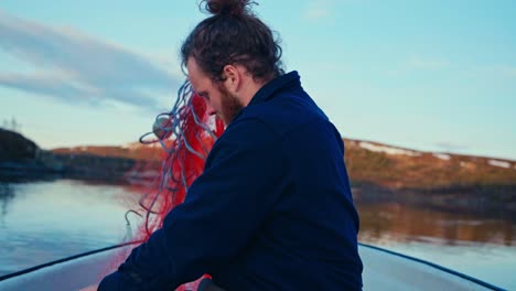 man on a boat getting his bait ready for fishing in norway - close up