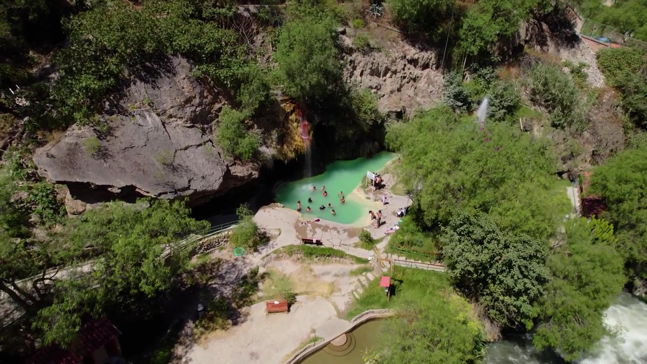 Vista aerea di turisti che si rilassano nelle terme turchesi di Mamahuarmi a Churin, Perù. Ideale per il turismo del benessere