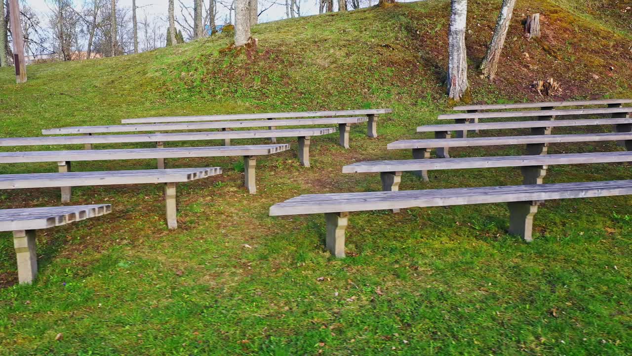 녹색 선명한 풀밭에 있는 공원에서 큰 행사를 위한 빈 나무 벤치