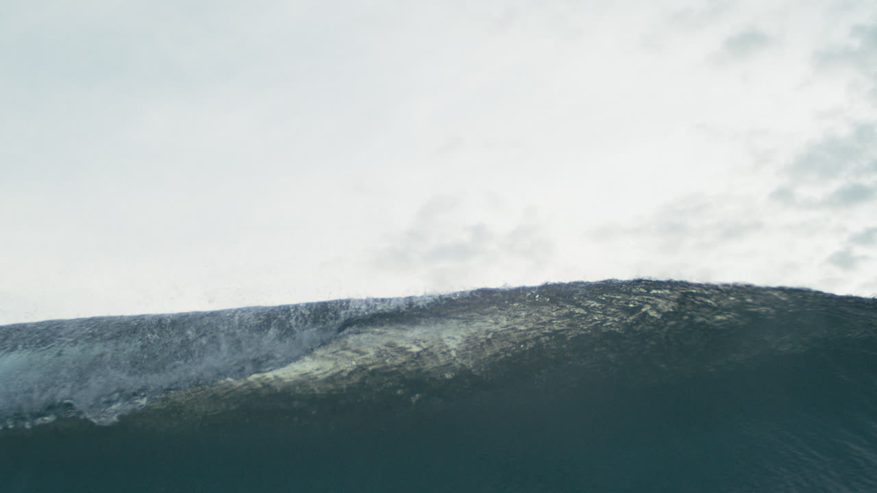 Turquoise wave curls and crashes in mesmerizing slow motion with rich surface texture