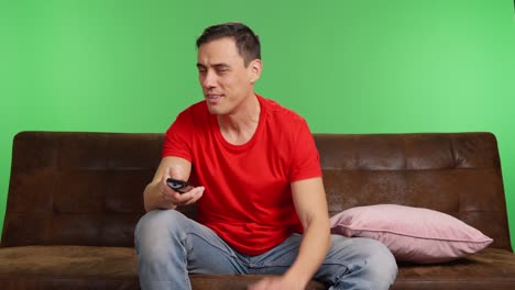 Bored man flipping channels on green screen