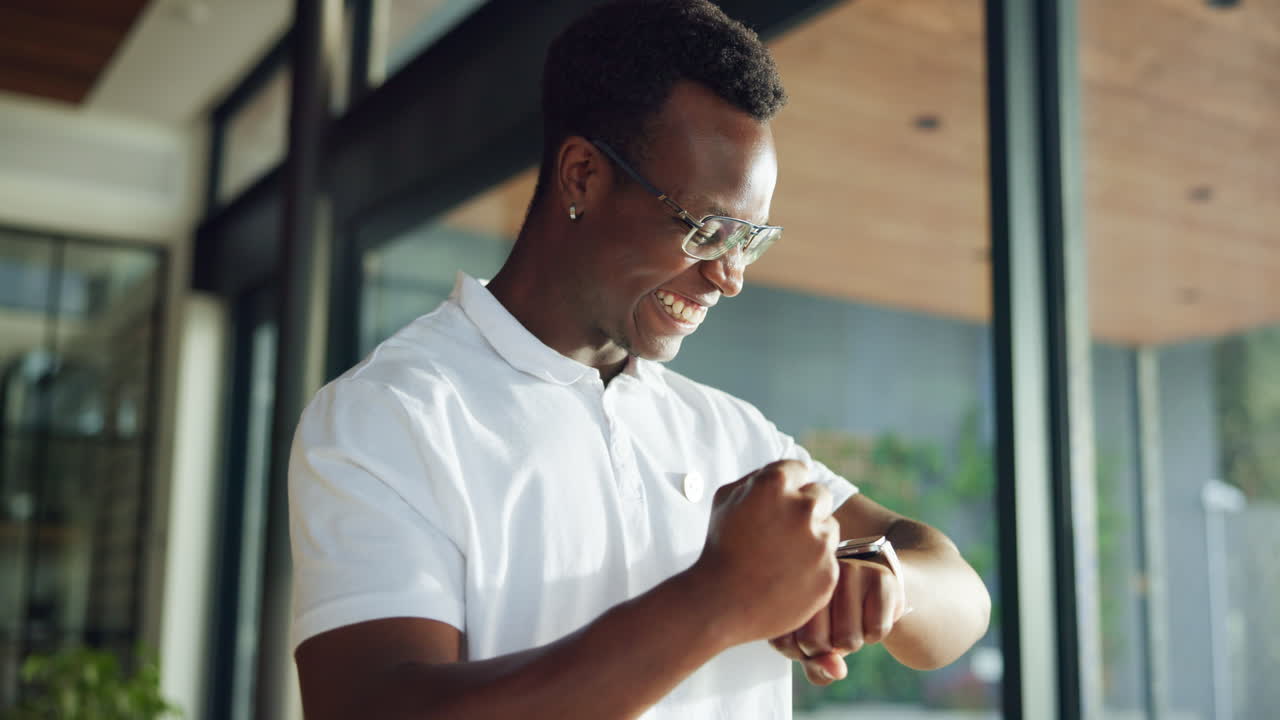 Happy Young Man Checks Smartwatch and Celebrates Success