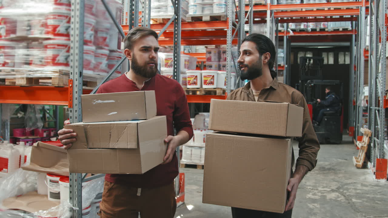 Male Workers Carrying Boxes in Warehouse