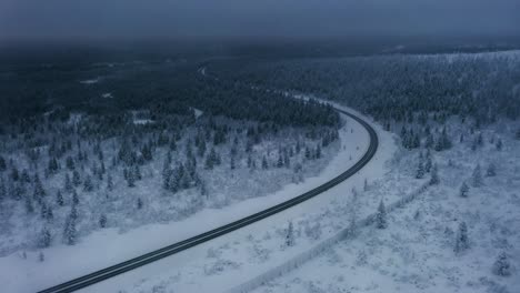 aerial view flying along the road to inari, foggy winter day in lapland