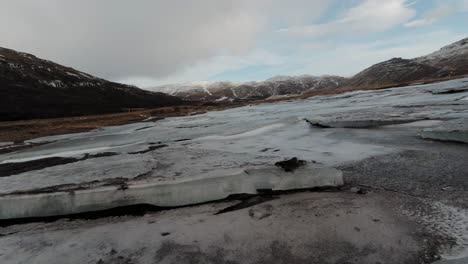 Sommerlandschaft-Im-Vordergrund-Des-Berges,-Bedeckt-Mit-Schmelzendem-Eis-Aus-Der-Wintersaison-In-Island