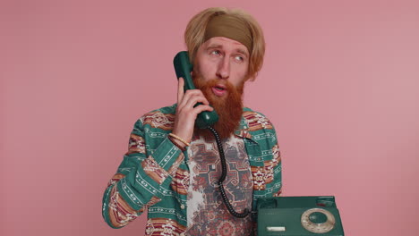 hippie redhead man talking on wired vintage telephone of 80s, says hey you call me back conversation