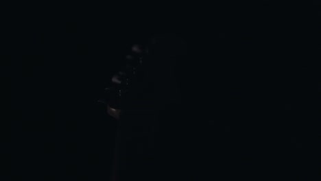 elemento de guitarra que revela la luz en completa oscuridad