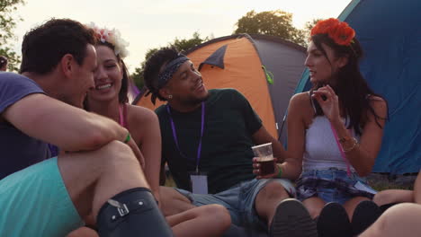 friends sitting in a circle at a music festival campsite