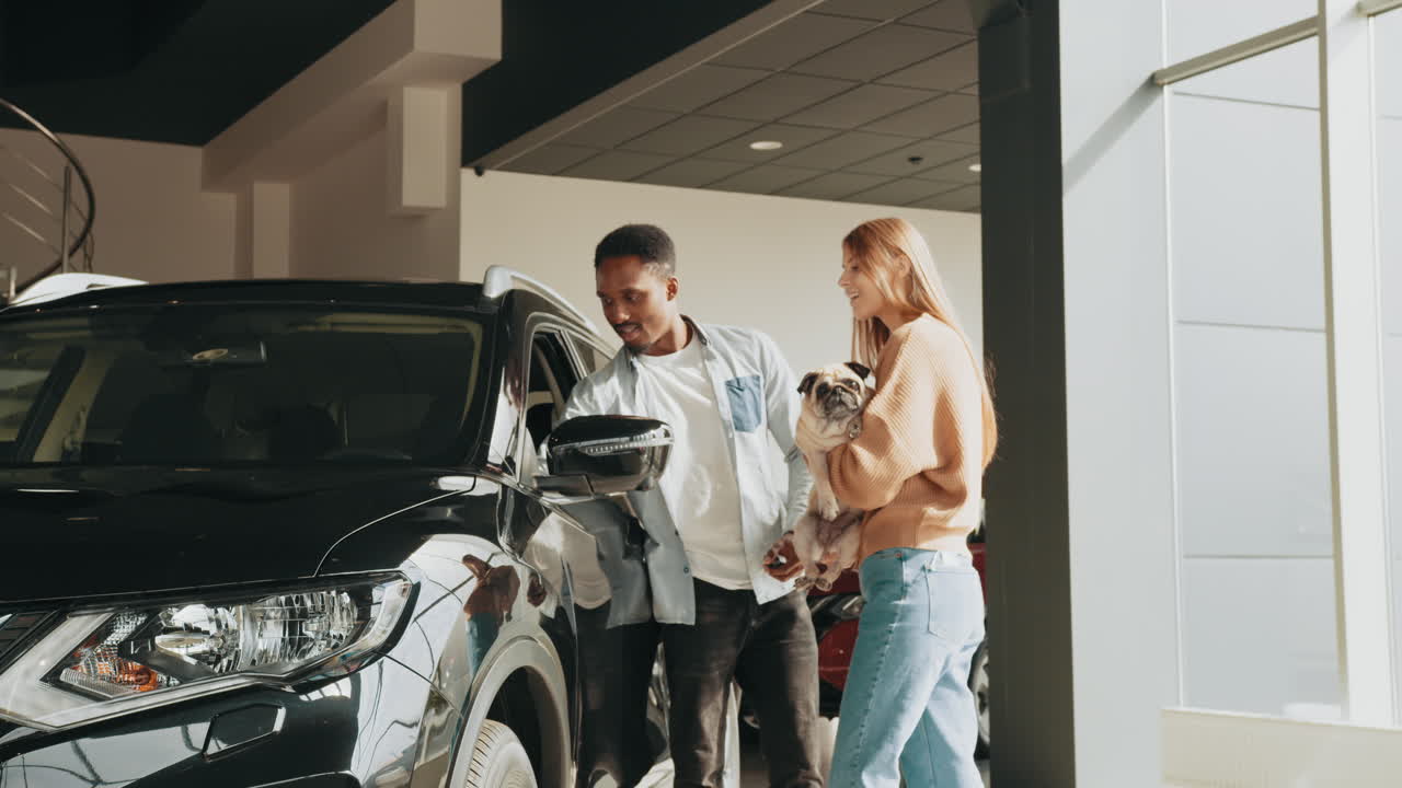una pareja comprando un coche nuevo con su pug