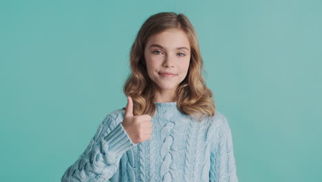 Teenage-Caucasian-girl-with-thumbs-up-looking-at-the-camera.