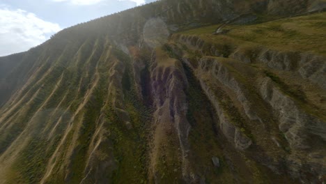 upward flight over mountain serpentine sharp turns road with rain drops through sun lights glare